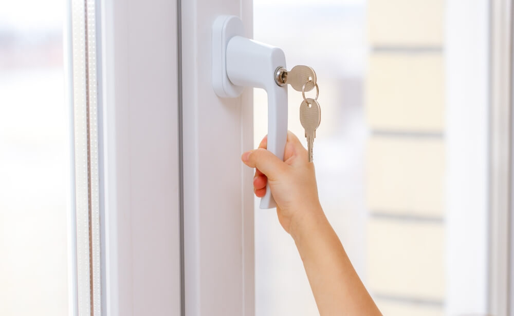 o persoana care incuie o fereastra termopan cu feronerie antiefractie