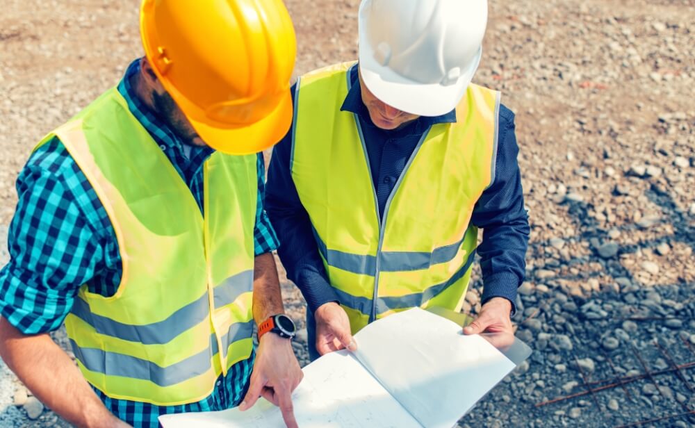 Investim în educație Două persoane care studiază un plan de șantier