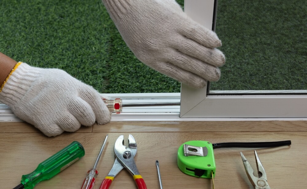 o persoana care instaleaza o plasa de insecte glisanta